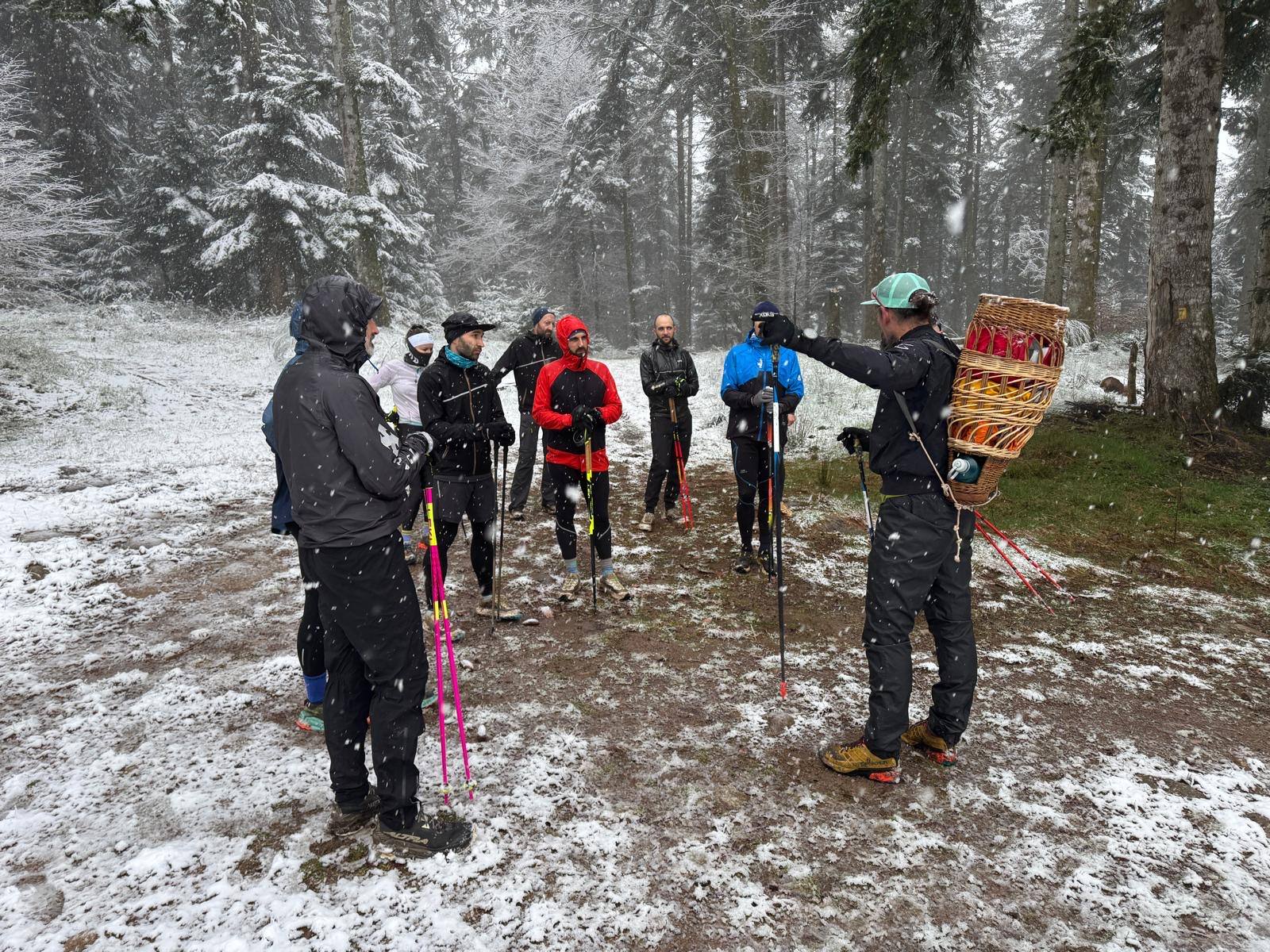 Briefing de la team sous la neige, en forêt, avant une sortie