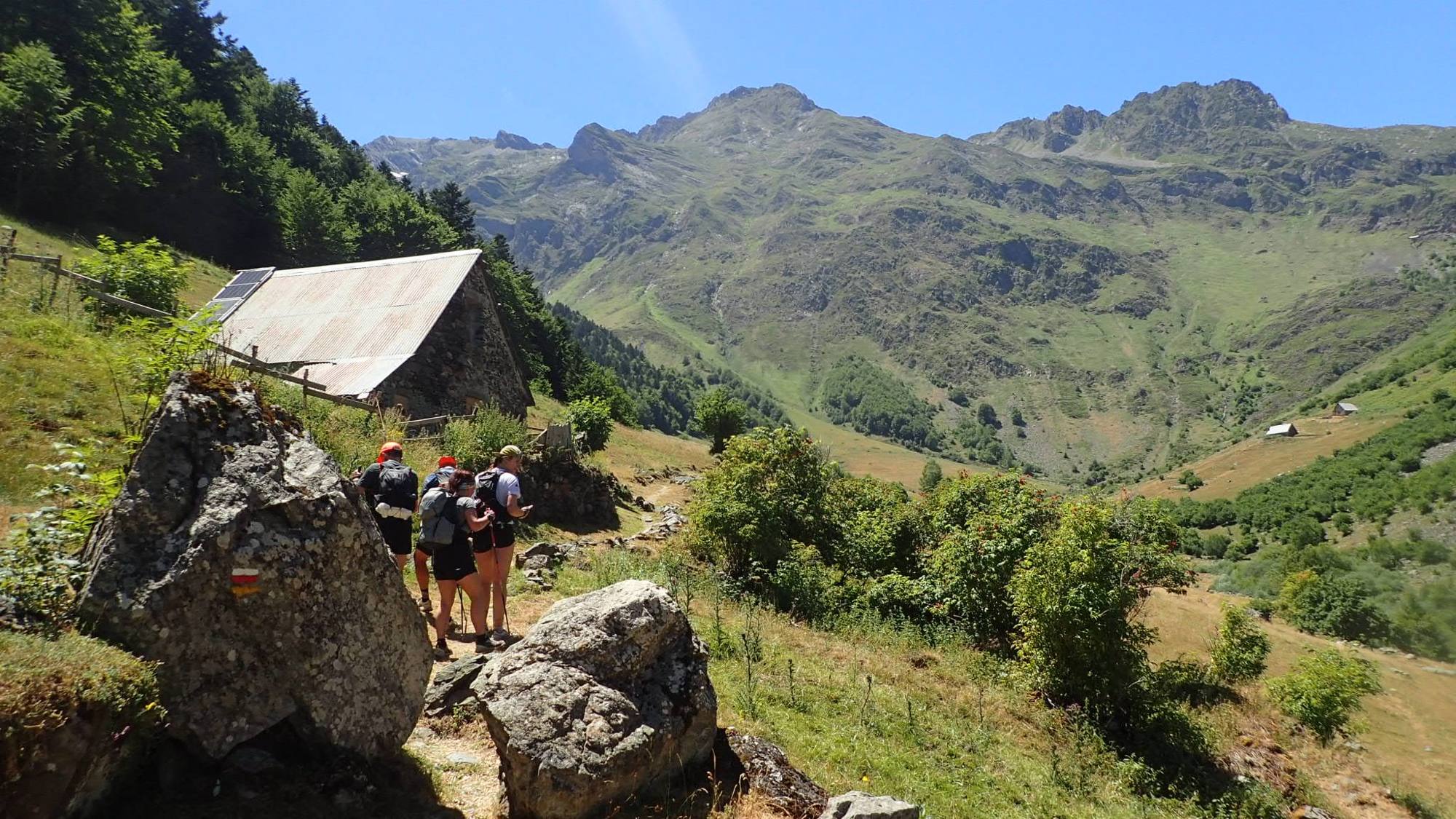Des membres de la team marchent en montagne, bâtons en main