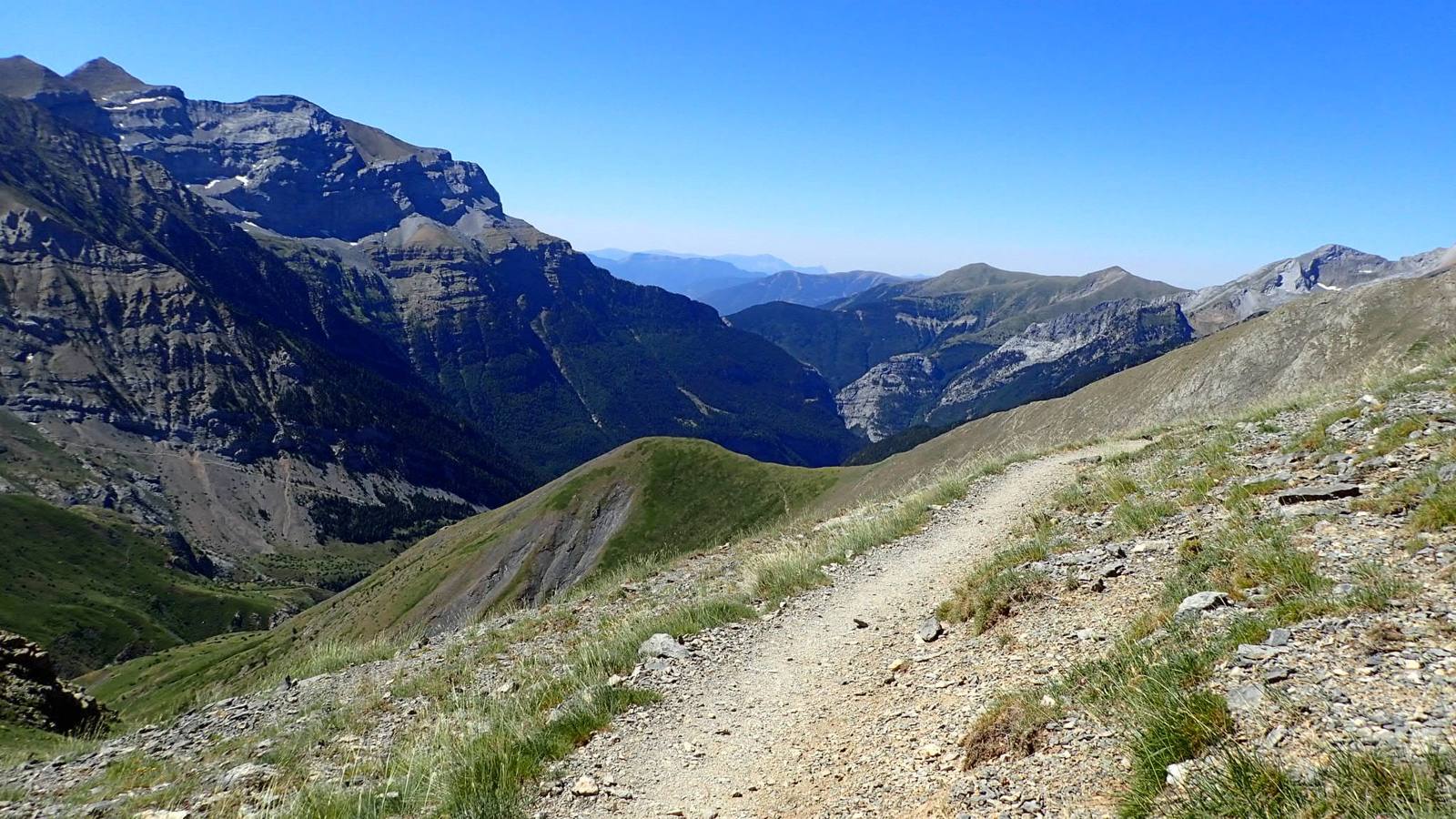 Sentier de trail en balcon au-dessus d’une vallée de montagne